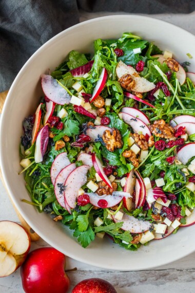 This apple salad recipe is delicious and refreshing! Fresh, peppery greens, crisp apples, and sharp white cheddar cheese combine perfectly with crunchy, spiced walnuts tossed in a bright, vibrant citrus dressing. Vegan-adaptable and gluten-free.