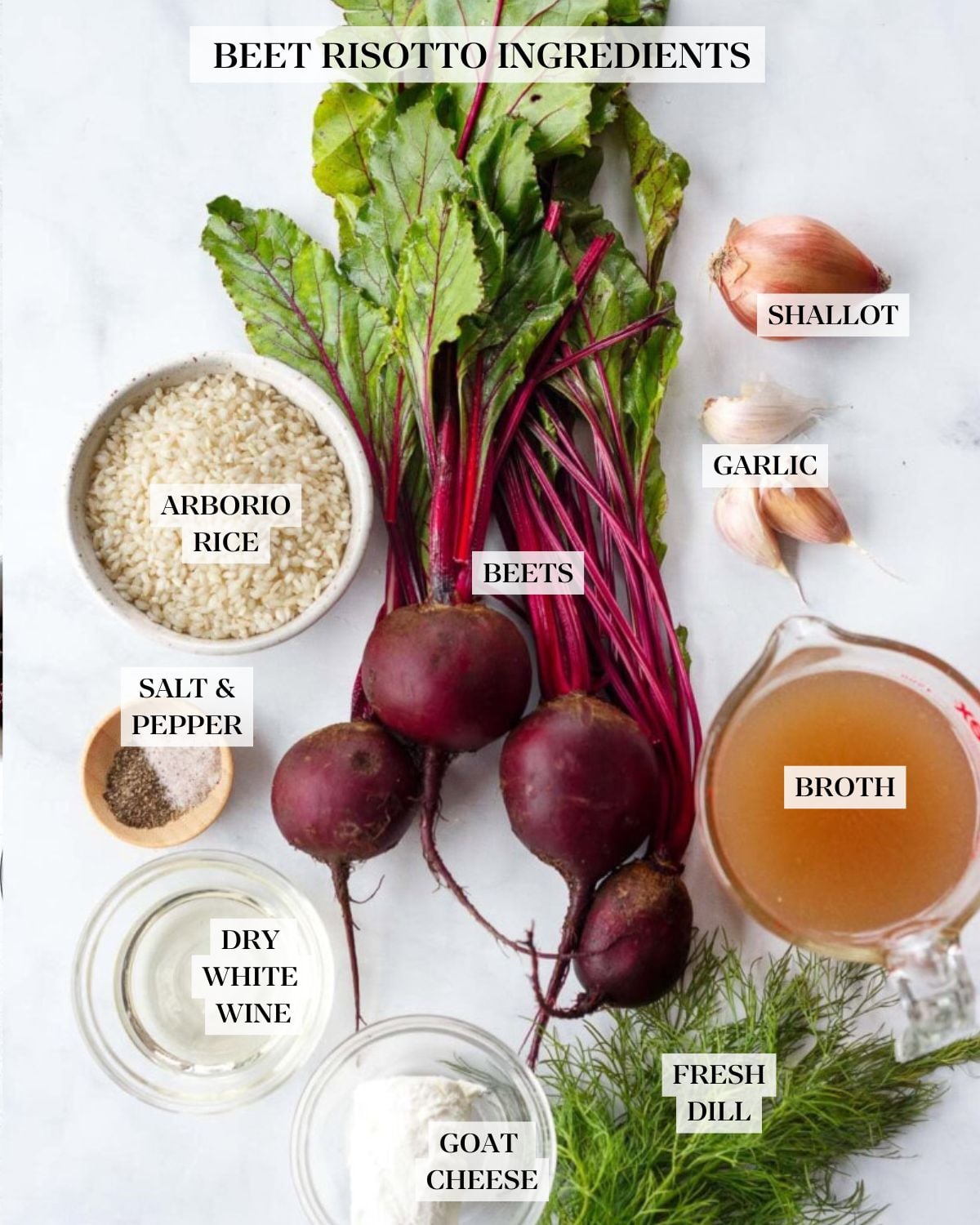 ingredients for beet risotto - shallot, garlic cloves, fresh beets with stems, bowl of arborio rice, measuring cup of broth, fresh dill bunch, and small dishes of salt, pepper, wine, and goat cheese.