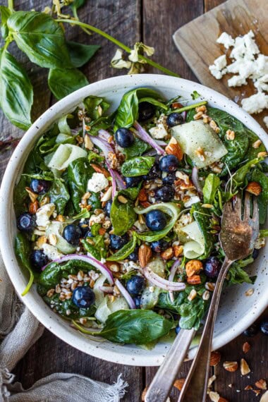 A vibrant and summery blueberry salad with spinach, farro, almonds, feta, and a tangy white balsamic cinnamon dressing—fresh, flavorful, and perfect for warm days.
