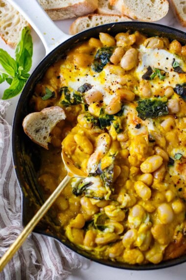 A fall-inspired recipe for baked beans with butternut sauce, kale, basil, and burrata cheese. A cozy vegetarian meal your whole family will love. Gluten-free.