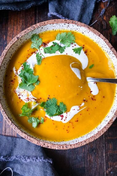 My chef's perfected recipe for glowing carrot and ginger soup is creamy and earthy, enhanced with turmeric.  Vegan and gluten-free in just 30 minutes!