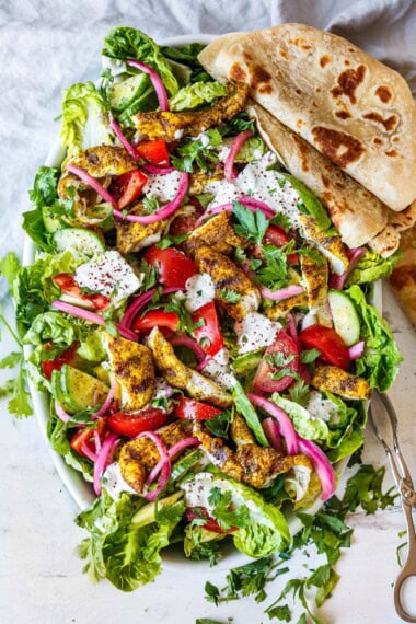 Mouth-watering, crunchy, fresh goodness is here in this amazing Grilled Chicken Salad! Made with little gem lettuce, grilled shawarma chicken, pickled onions and topped with tahini yogurt dressing.