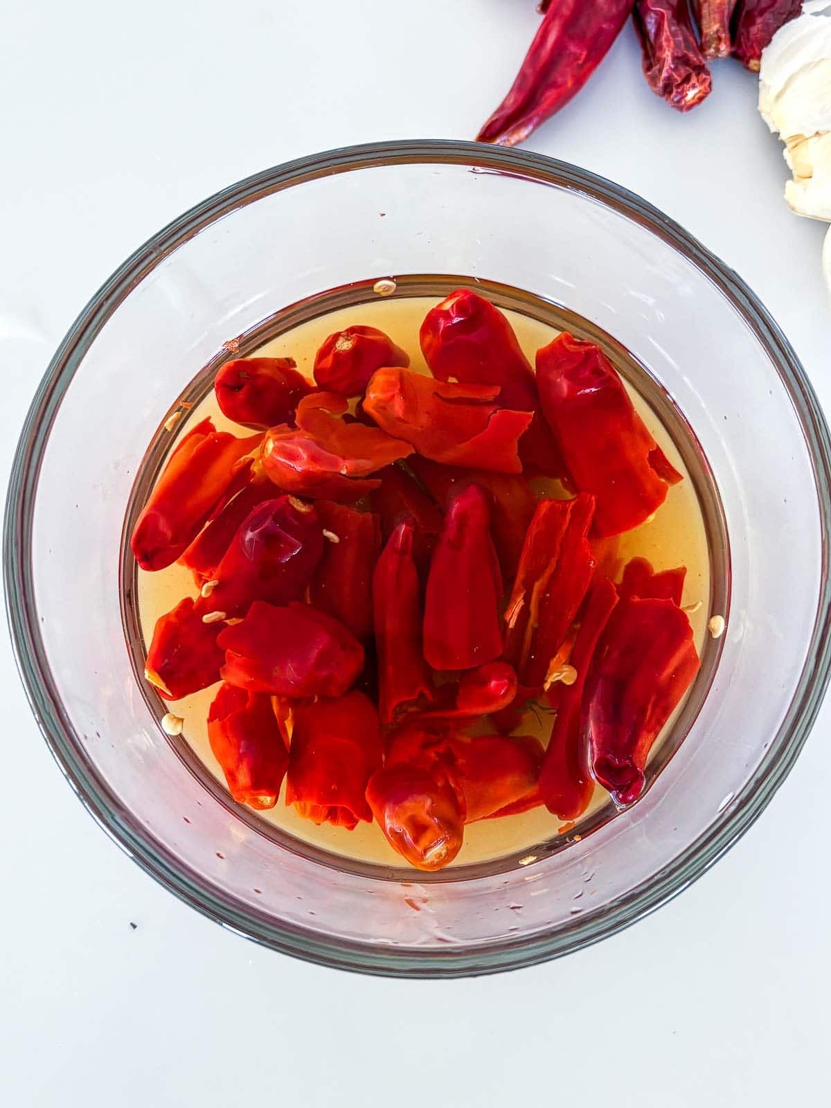 red chilies soaking in glass bowl of hot water.