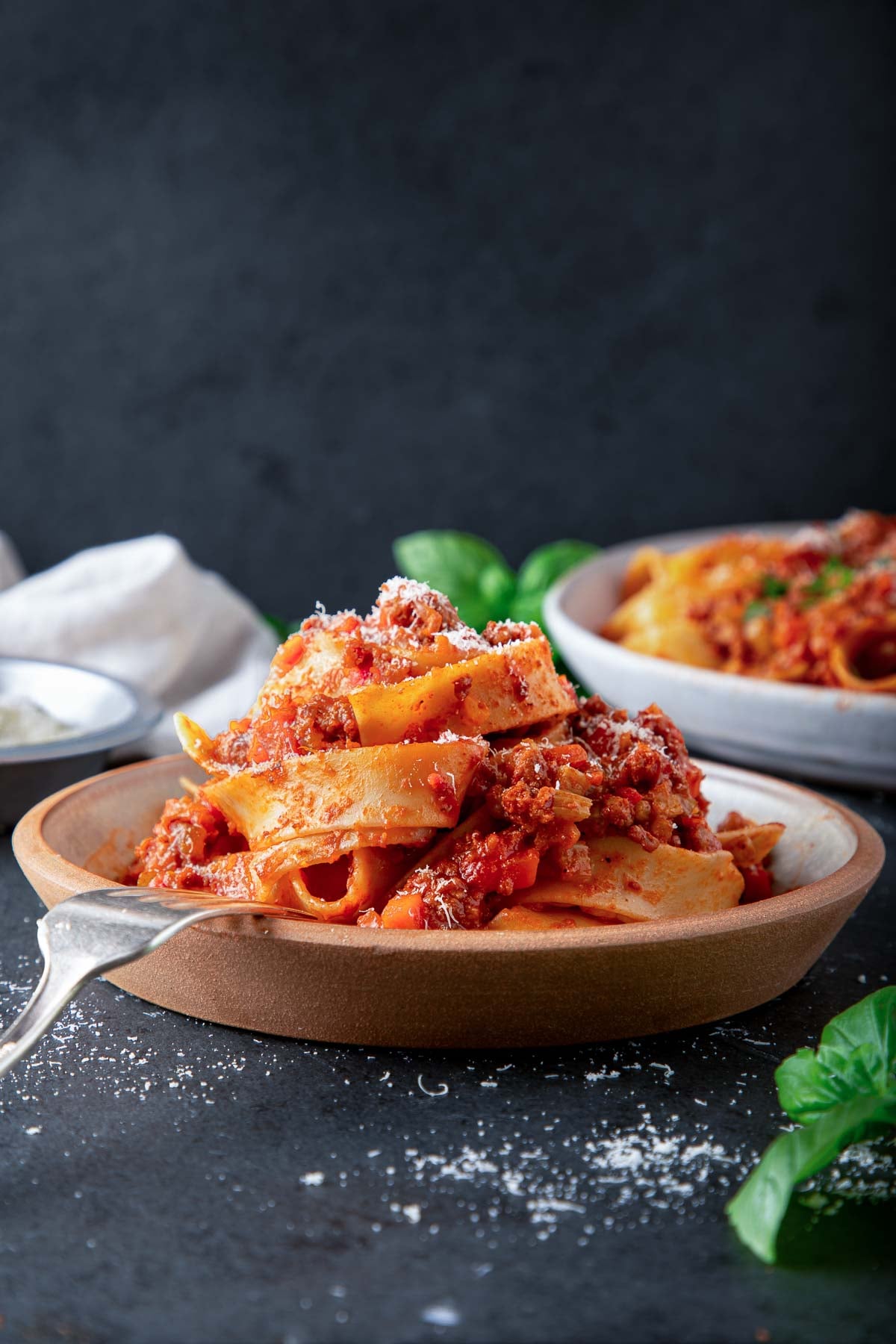 plate of bolognese pappardelle with grated cheese.