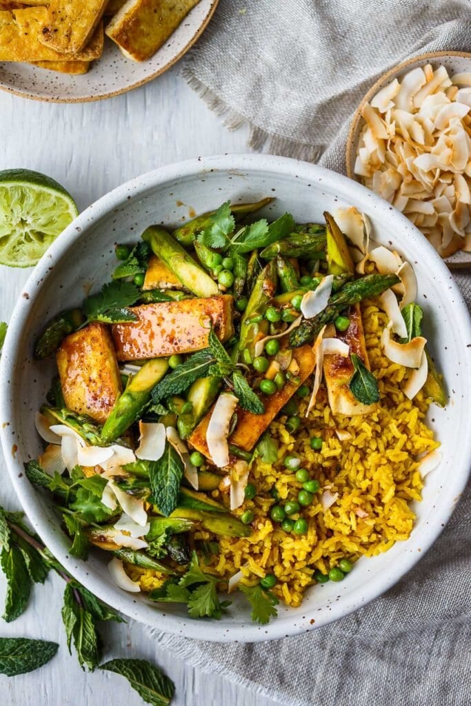 Best vegan recipe: coconut rice bowl with jasmine rice topped with peas, asparagus, mint, toasted coconut, and seared tofu.
