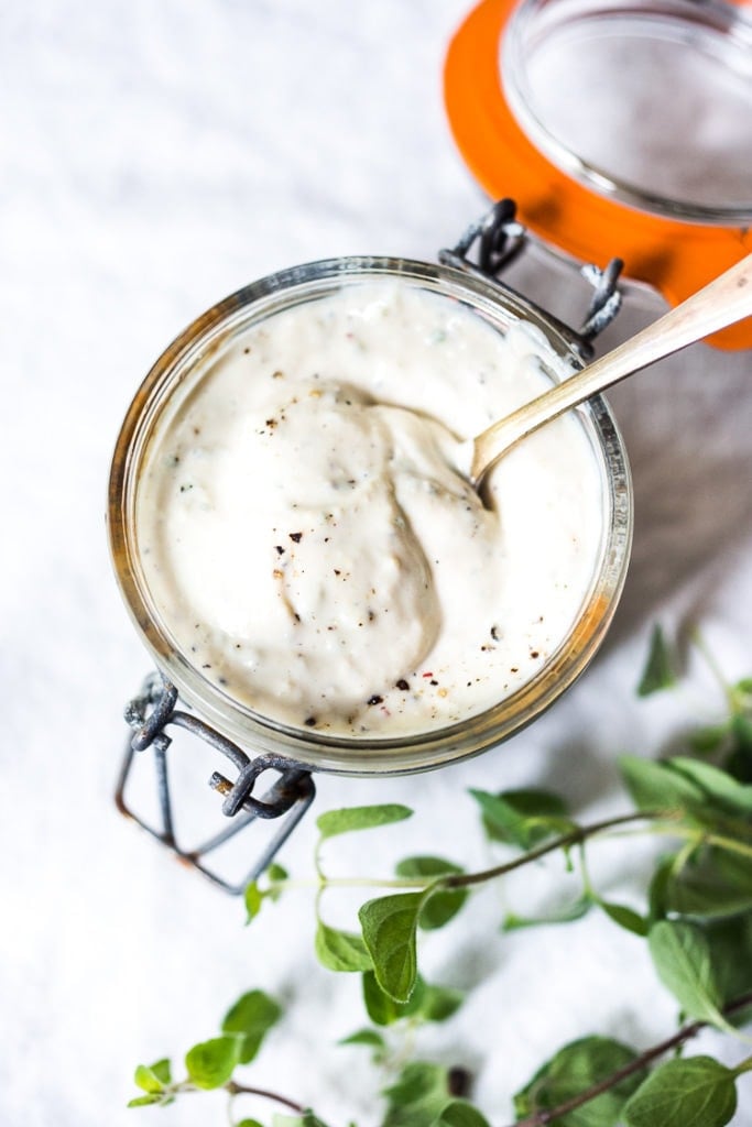 jar of vegan ranch dressing with silver spoon in the jar. 