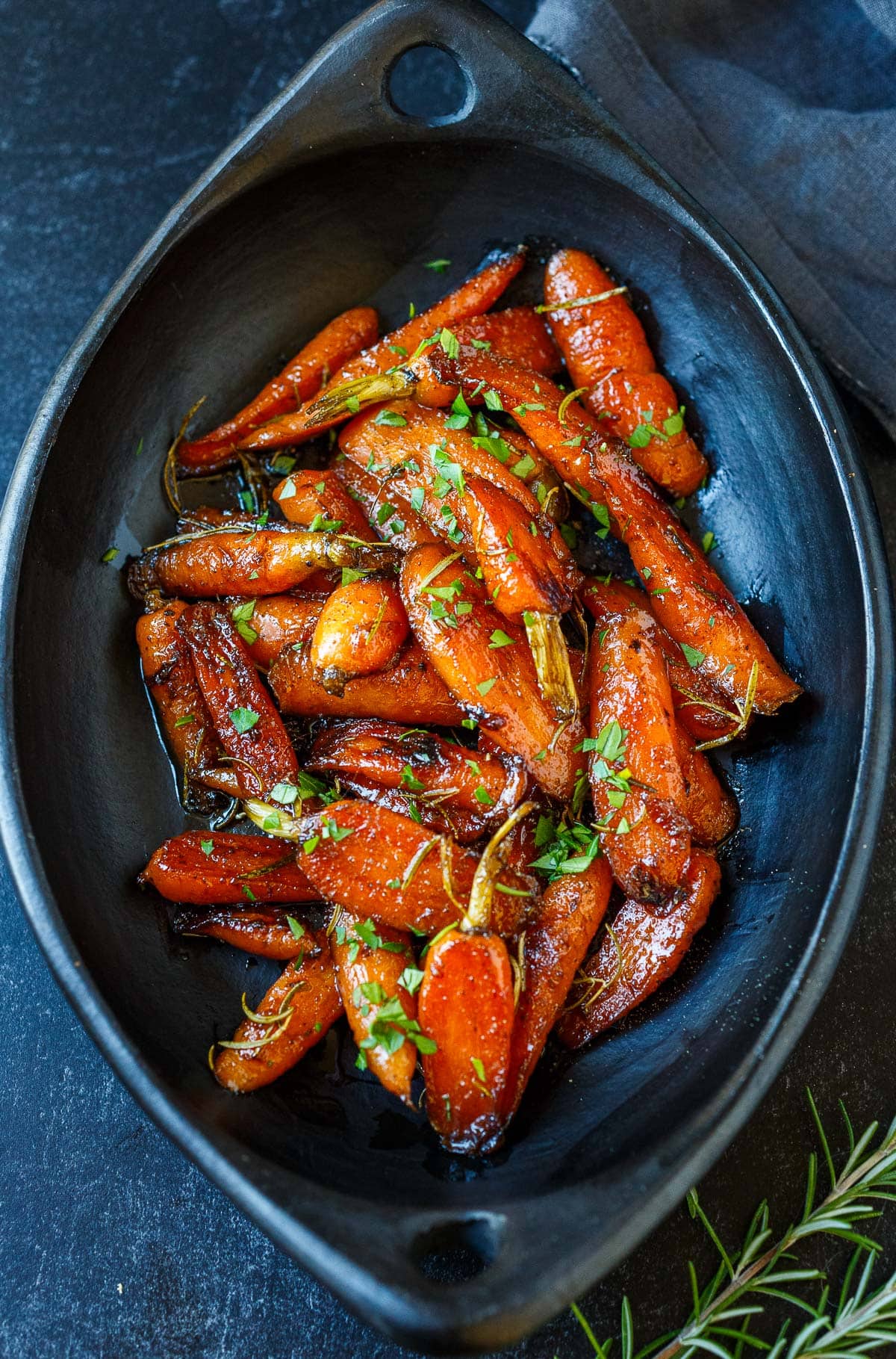 maple glazed carrots with fresh herbs in serving dish, one of our most popular carrot recipes. 