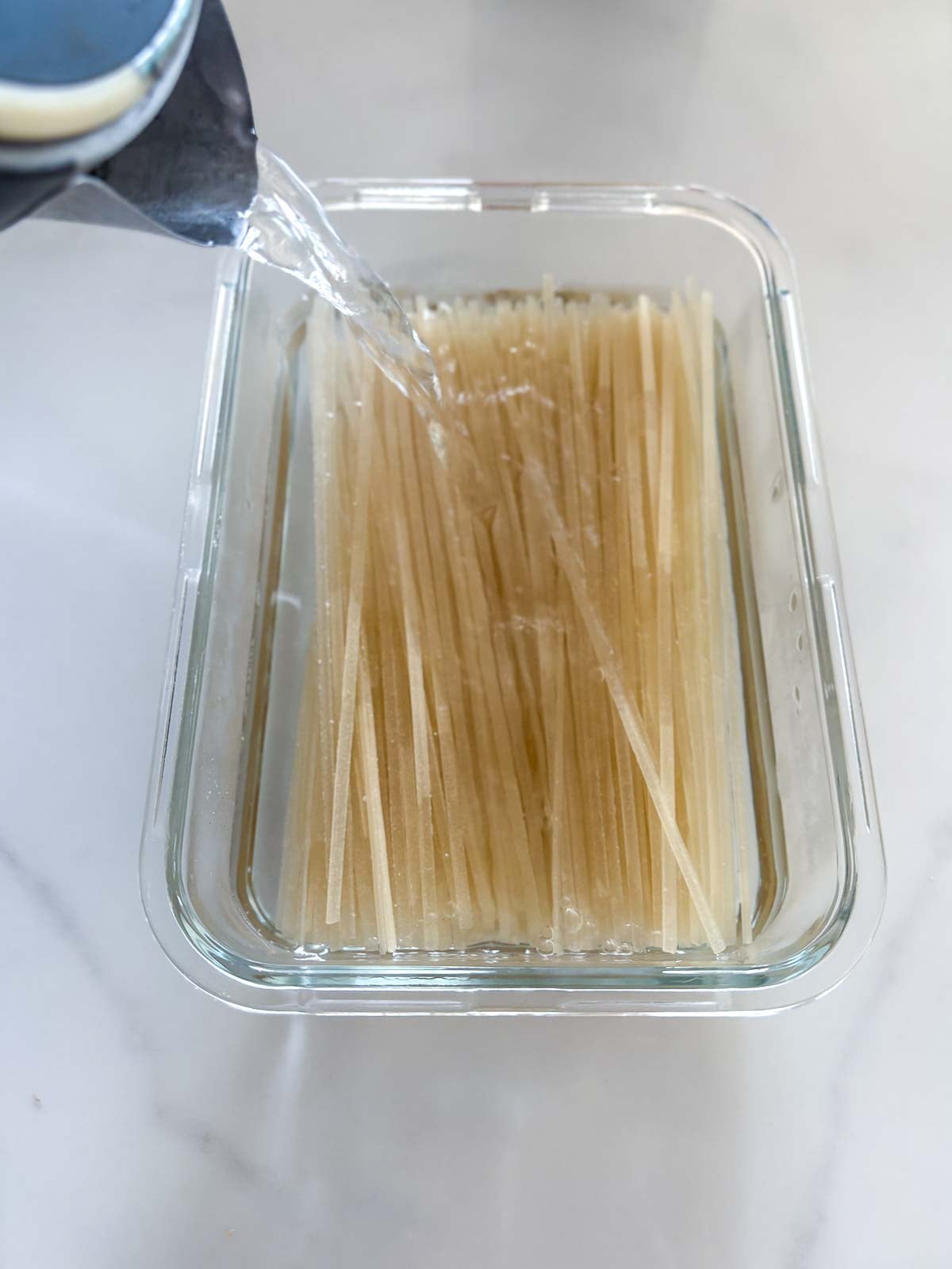 Soaking rice noodles in hot boiling water. 