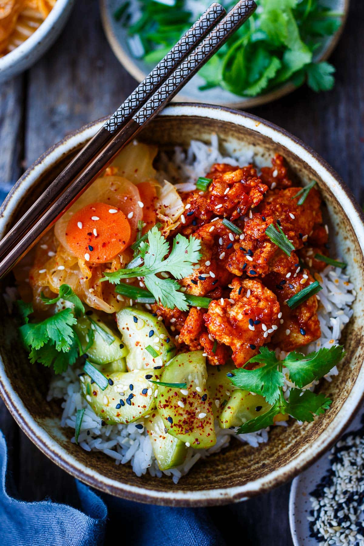 Korean tofu rice bowls over rice with gochujang tofu, pickled veggies, cilantro, and scallion. 