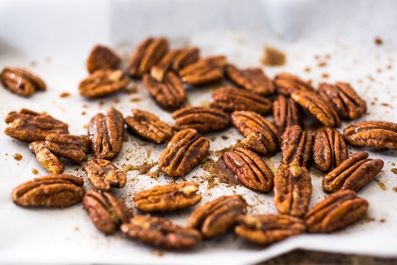 toasted Chipotle Maple Pecans on parchment-lined baking sheet. 
