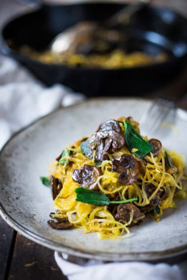 This delicious spaghetti squash recipe is made with a baked spaghetti squash, savory mushrooms, garlic, and sage-a flavorful, healthy vegetarian dinner! It's a low-carb, gluten-free meal that feels like a comforting pasta dish, perfect for fall. Keep it vegan or add pecorino cheese.